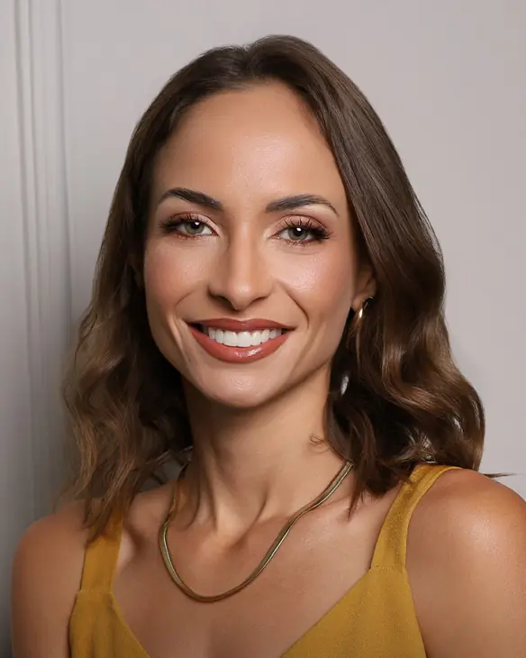 Dra. Eduarda Costa sorrindo, de blusa mostarda